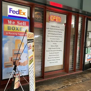 Shop exterior, services listed under open lit sign.