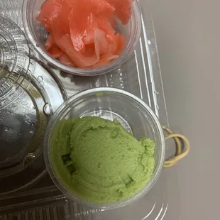 a container of sushi and a bowl of guacamole