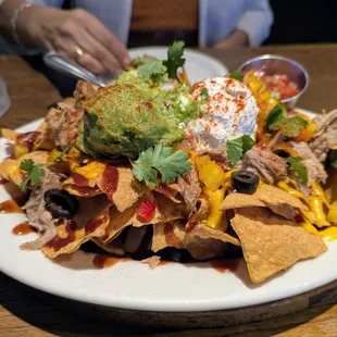 The kahlua pork nachos are large and lean heavily sweet (bbq sauce) with only a hint of piquancy in the tiny ramiken of salsa.