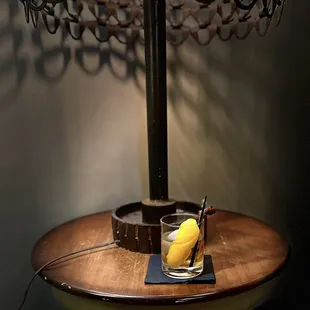 a glass with a drink and a banana on a table