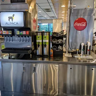 Inside. Double-side drink and condiment station. Self-serve fountain drink machine, tea, eating utensils, and dipping sauces.