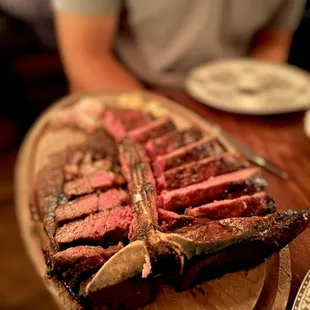 a large steak on a wooden platter