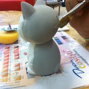 My daughter making a Cheshire Cat bank.