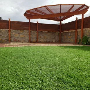 Wood Privacy Fence, Fan style Pergola, Solar lighting, Artificial Turf, Acid Stain Concrete, Landscape.