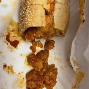 a half eaten sandwich on a paper plate