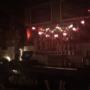 a dimly lit bar with a lot of bottles