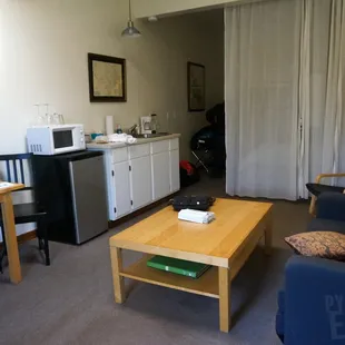 The living room with a sheer curtain to divide it from the bedroom