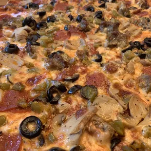 a pizza with olives and pepperoni