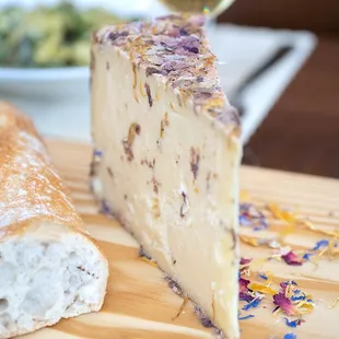 a piece of cheese and bread on a cutting board