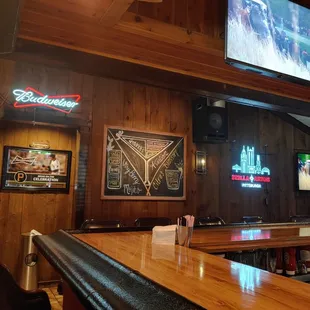 a bar with wooden walls and a television