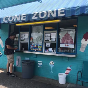a man standing in front of an ice cream shop