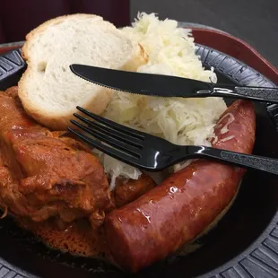 a plate of meat, rice, and bread