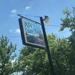 a sign for al's country market