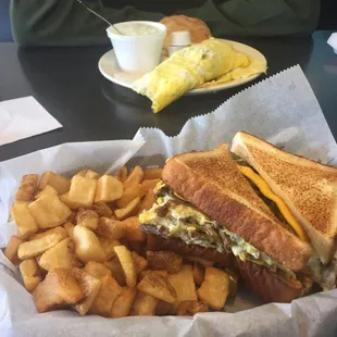 hobo sandwich and hash browns in the front, Al&apos;s omelet, grits and biscuit in the back