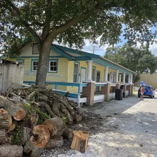 ows a pile of logs in front of a mobile home
