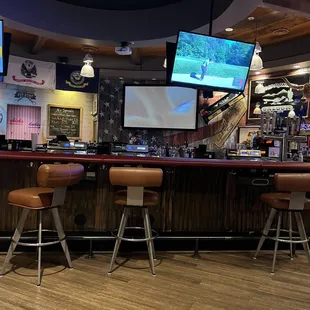 a bar with two televisions on the wall