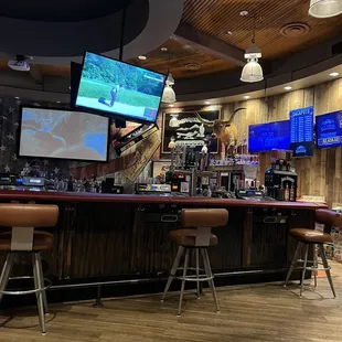 a bar with a lot of tvs