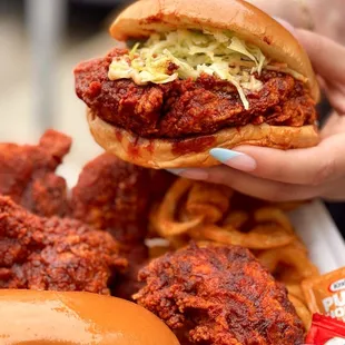 a person holding a sandwich and fries