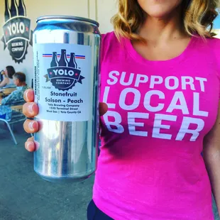 a woman holding a can of beer