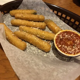 a basket of breadsticks and dipping sauce