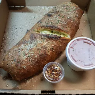 Hot stromboli to go. Much bigger than I expected and it's medium!