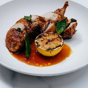 a plate of grilled meat and a lemon