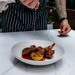 a man pouring wine over a plate of food