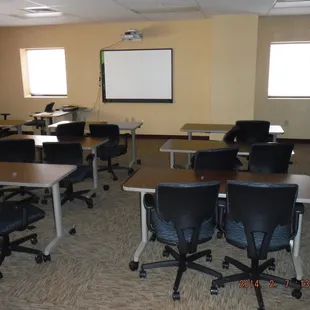 an empty classroom with desks and chairs