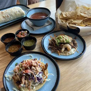 Cali burrito, nacho chips with salsa, steak and shrimp taco, fish taco