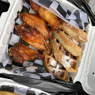 chicken wings and french fries in a styrofoam container