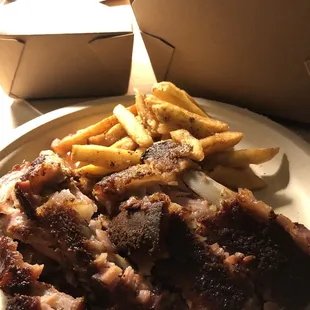 a plate of ribs and french fries