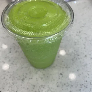 a green smoothie in a plastic cup