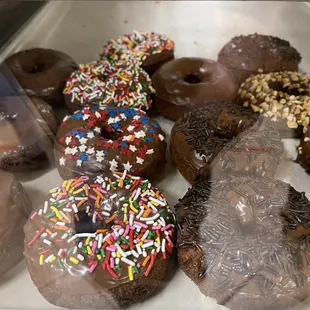 a variety of chocolate donuts with sprinkles