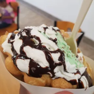 a hand holding a cup of ice cream