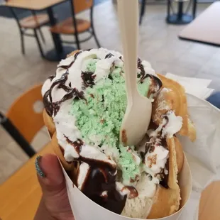 a hand holding a cone of ice cream