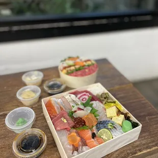 a wooden box of sushi with a variety of toppings