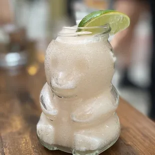a close up of a glass of a drink with a lime slice on top
