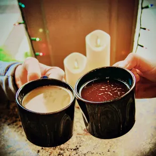 two people holding cups of coffee