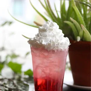 a red drink with whipped cream