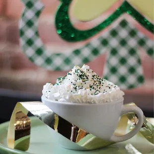 a cup of coffee with whipped cream and sprinkles