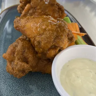 a plate of fried chicken with a side of ranch dressing