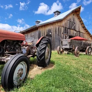an old tractor in front of a barn