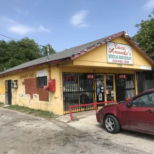 a red car parked in front of a yellow building
