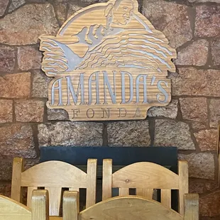 a table and chairs in front of a stone wall