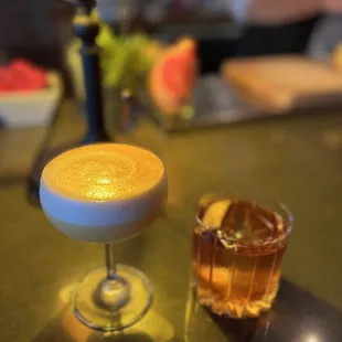 a glass of alcohol and a drink on a table