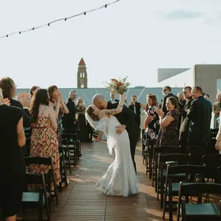 Bride and groom walking down the aisle (smooching)