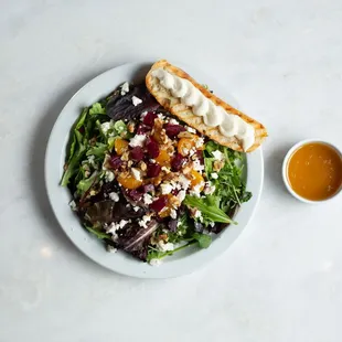 Beet Salad - feta, walnuts, and mandarin oranges on arugula, spring mix, and herbed ricotta. Served with a crostini &amp; honey-goat cheese.