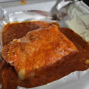 a piece of meat covered in sauce