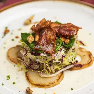 Pear Salad: A refreshing blend of radicchio, frisée, sweet peas, maple bacon, walnuts, and blue cheese fondue.