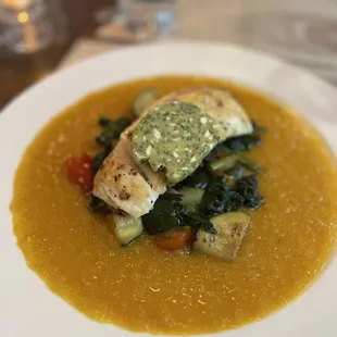 a bowl of soup with fish and vegetables
